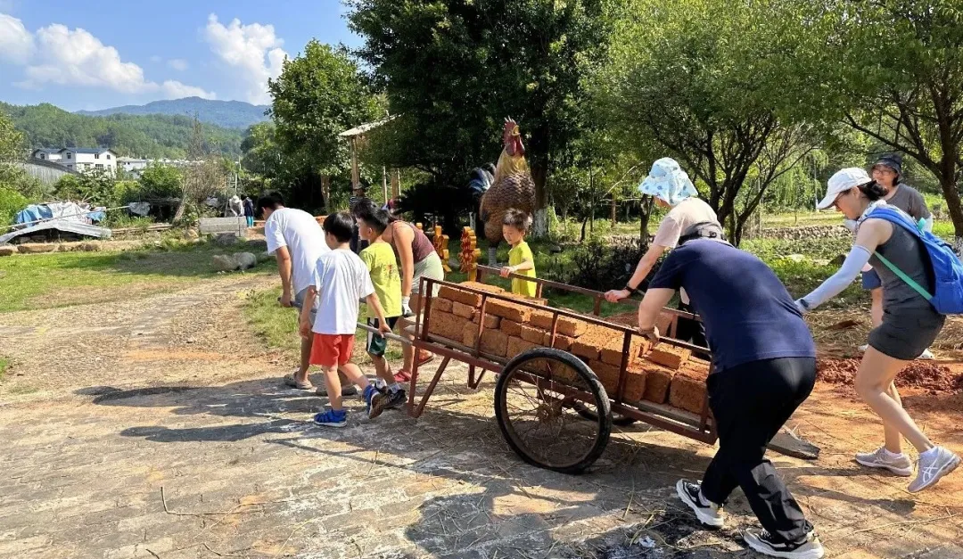参加营地的家长和孩子们用板车合作搬砖